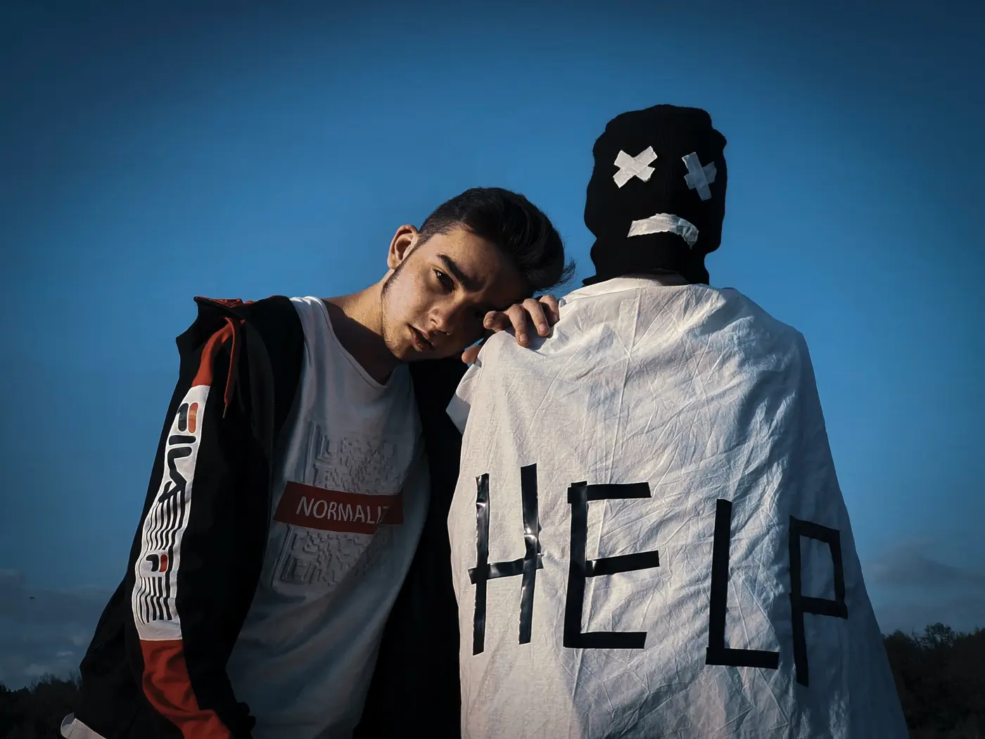 Due ragazzi, uno con la scritta help: chiedere aiuto per la dipendenza
